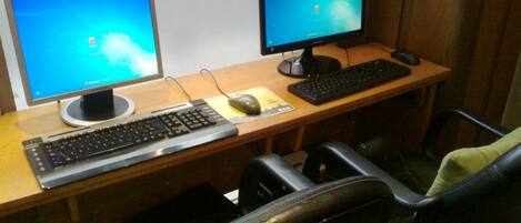 A workspace with two monitors, a keyboard, a mouse, and a chair.