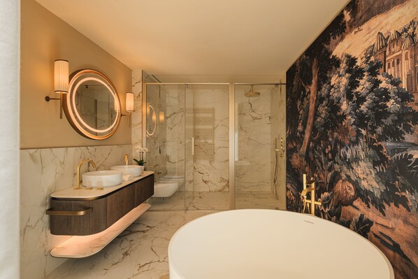 Een moderne badkamer met een groot bad, twee wastafels en een douchehoek.