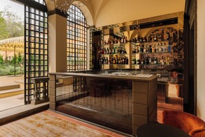 Una zona de bar con una amplia estantería para vinos y un expositor de vidrio.