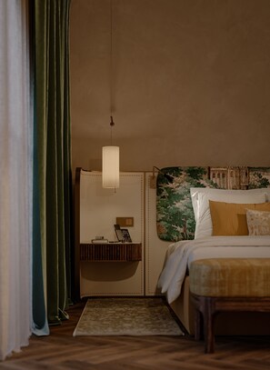 Habitación de hotel con cama, mesita de noche, lámpara y vista a un edificio a través de una ventana.