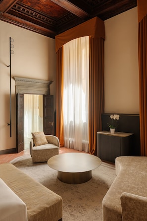 A room with a fireplace, a round coffee table, and two armchairs.