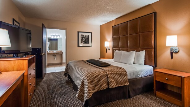 A hotel room with a bed, a TV, a bathroom, and a nightstand. - Best Western Inn Of Pinetop (Pinetop)