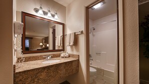 A bathroom with a granite countertop, a sink, a mirror, and a shower. - Best Western Inn Of Pinetop (Pinetop)