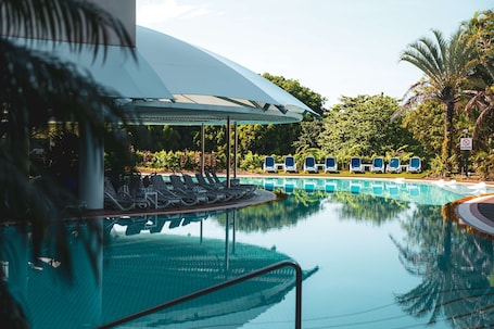 Una piscina al aire libre, sillones reclinables de piscina