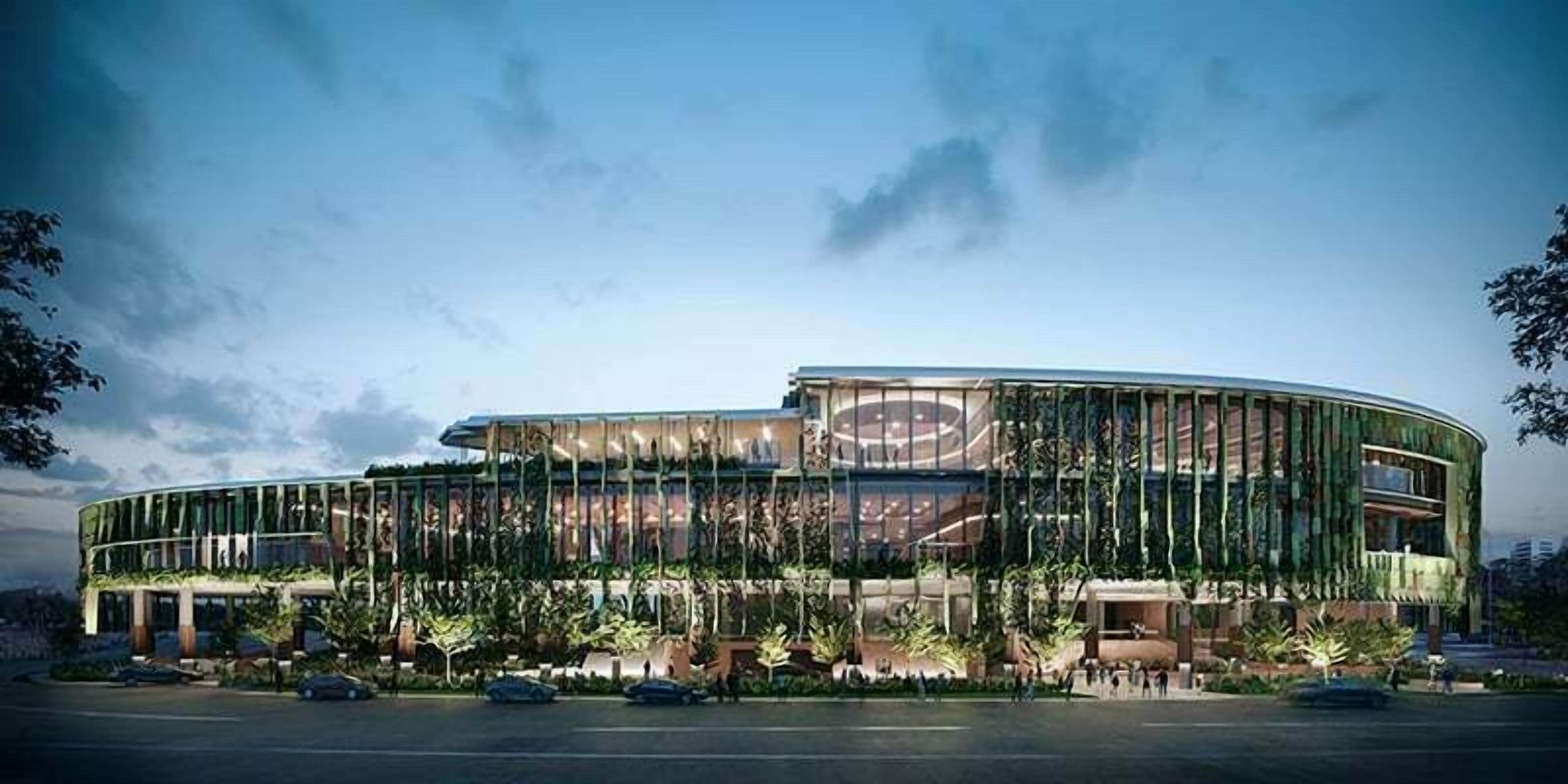 A modern building with a curved facade, large windows, and a central circular feature.