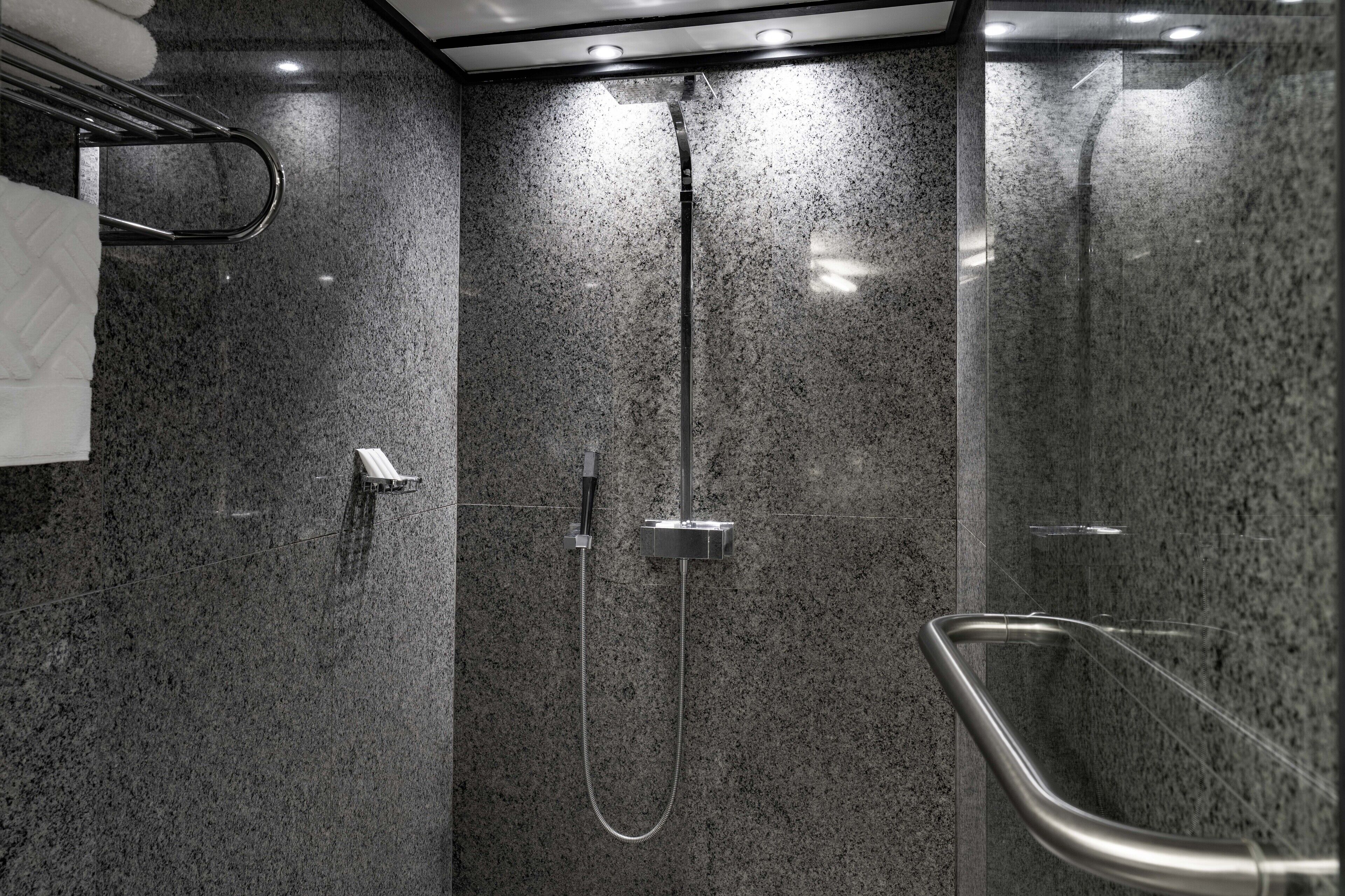 Ein modernes Duschbad mit Glasabtrennung, Handbrause und Wandarmatur.