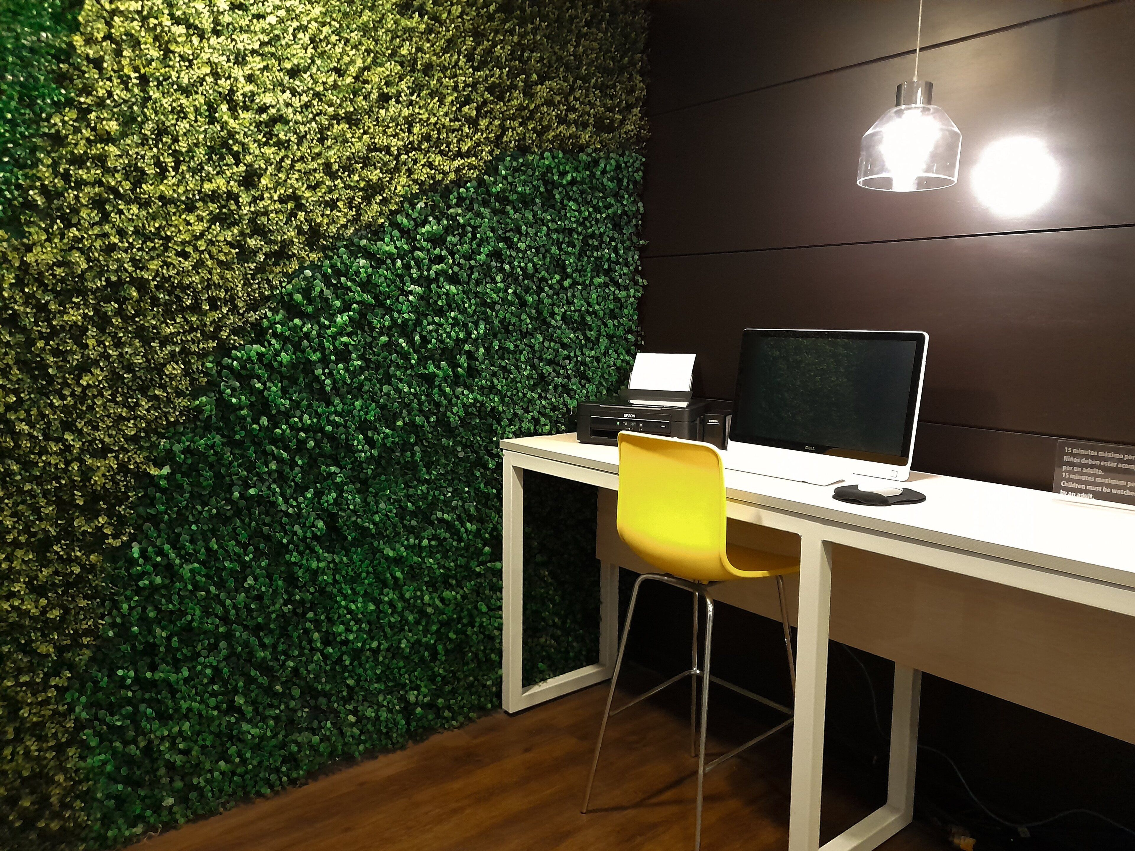 Un espace de travail comprenant un bureau, un ordinateur portable, une imprimante et une chaise.