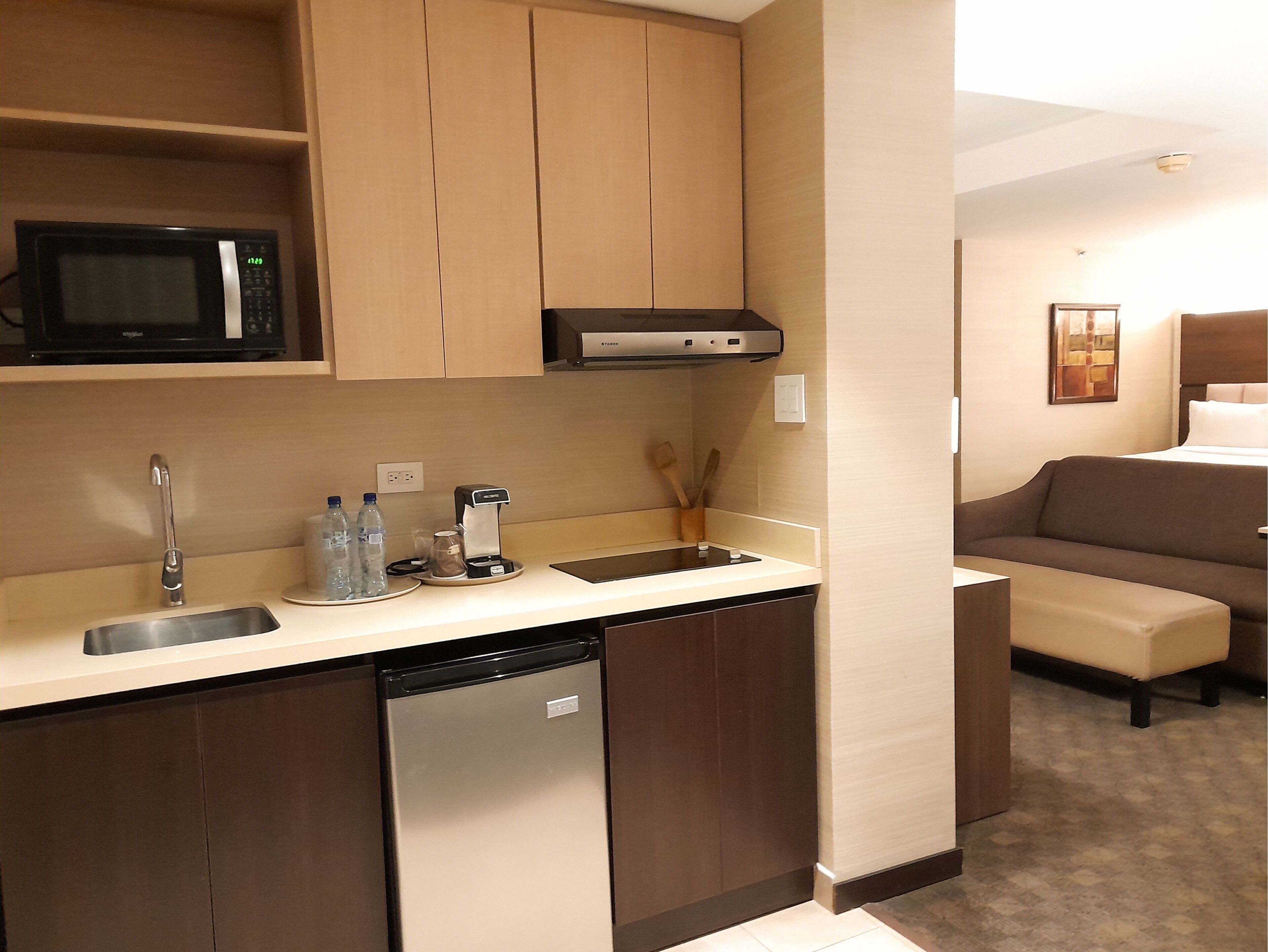 A compact kitchen with a microwave, coffee maker, and dishwasher.