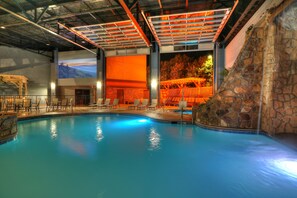 Una piscina interior con pared de piedra y un mural de un paisaje.