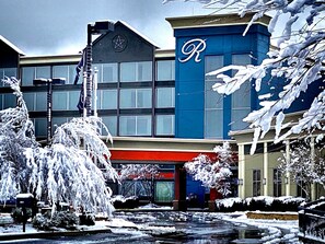 Experience the unique blend of modern and traditional architecture at this hotel, featuring a large 'R' logo and a decorative star on the roof.