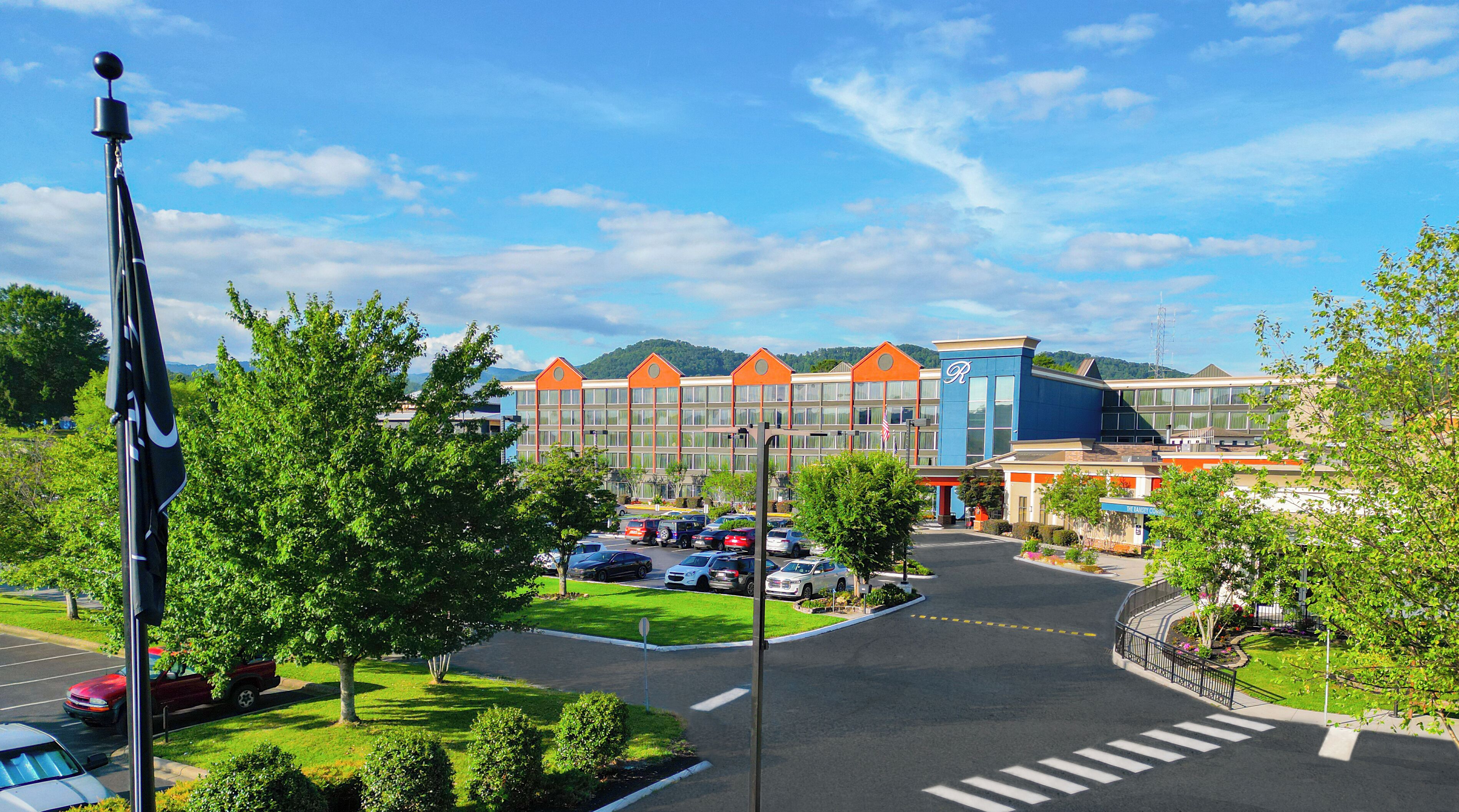A hotel with a parking lot, multiple buildings, and a flagpole.