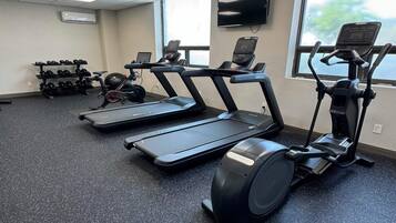 A gym with treadmills, an elliptical, and a weight rack.