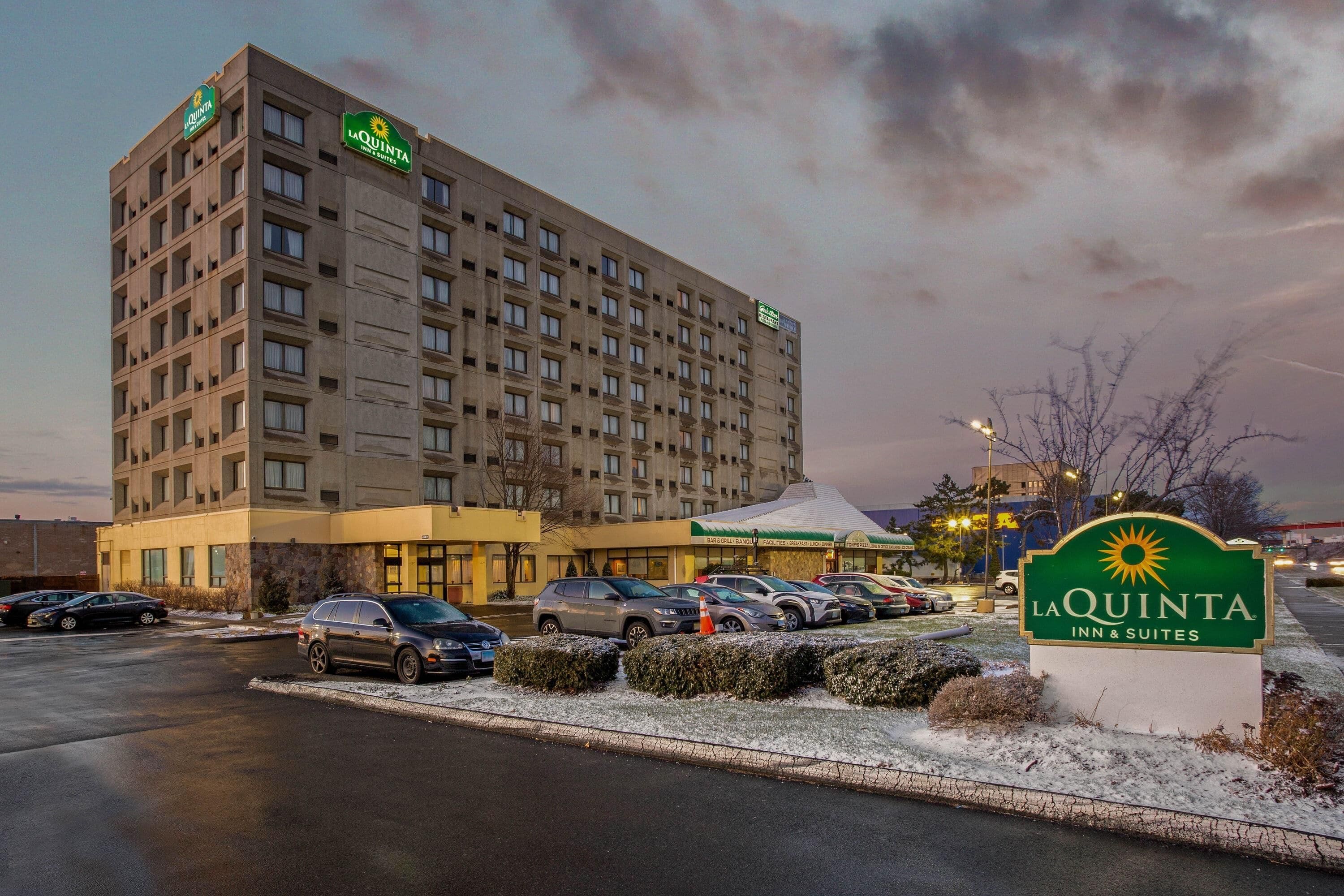 Ein mehrstöckiges Hotel mit Parkplatz und einem Schild für La Quinta Inn & Suites.
