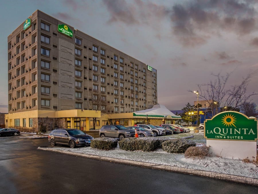 A multi-story hotel with a parking lot and a sign for La Quinta Inn & Suites.