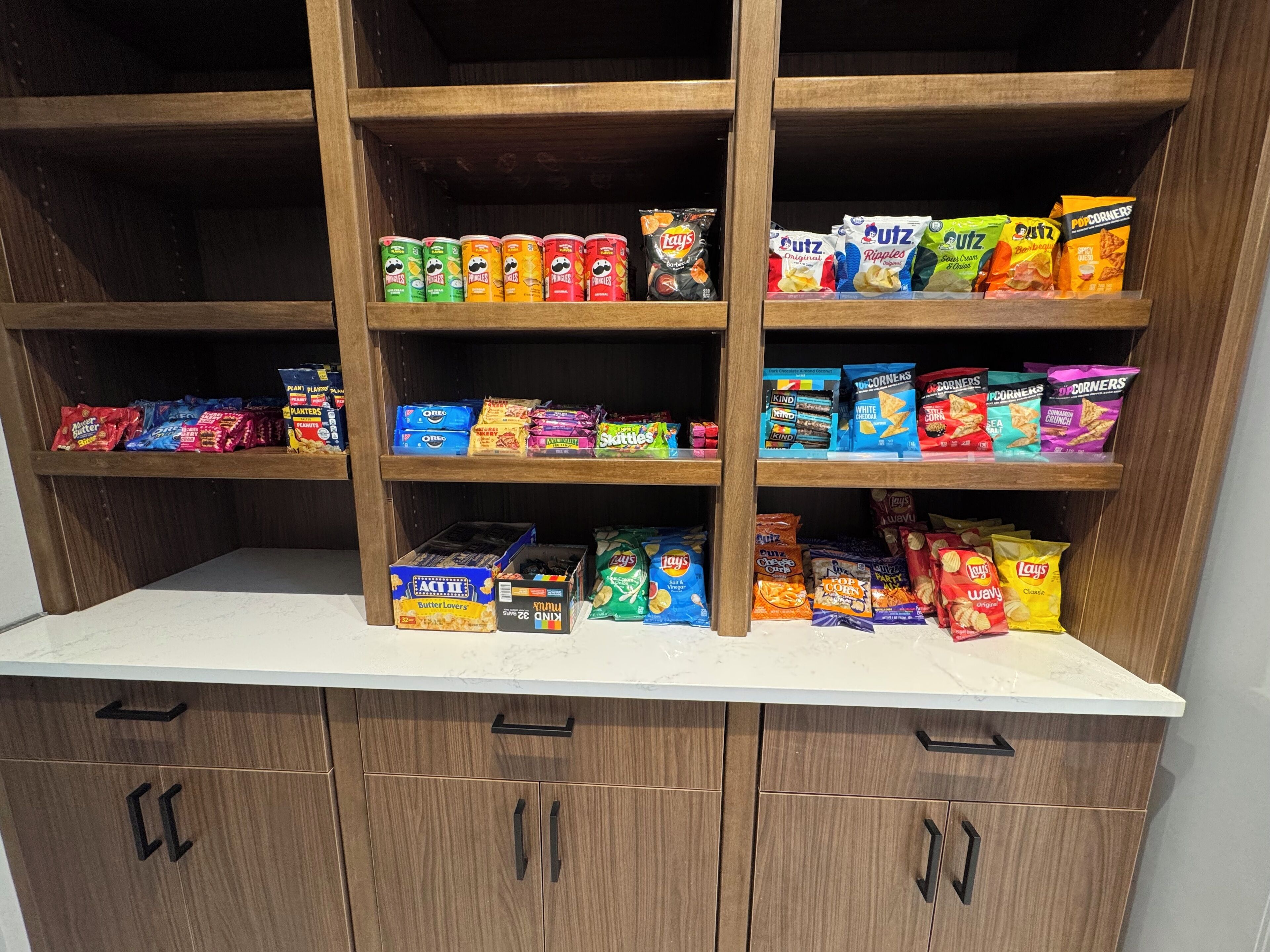 Eine Speisekammer mit Regalen, gefüllt mit verschiedenen Snacks und verpackten Lebensmitteln.