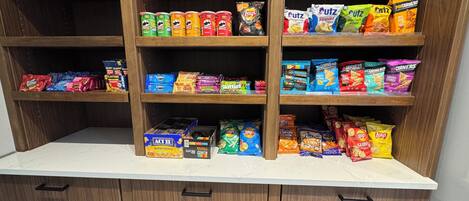 A pantry with shelves stocked with various snacks and packaged foods.
