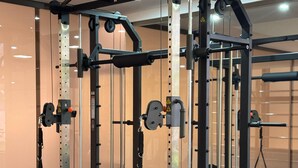 A gym with a squat rack, bench press, and various weight plates. - Castro's Park Hotel (Goiania)