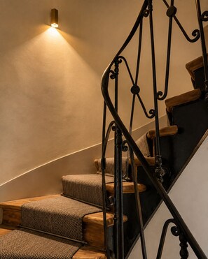 Un escalier avec une rampe en fer forgé et des marches en bois.