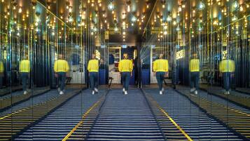 A room with mirrored walls and a patterned floor, creating a reflective effect.