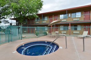Relax by the pool surrounded by comfortable lounge chairs and a table.