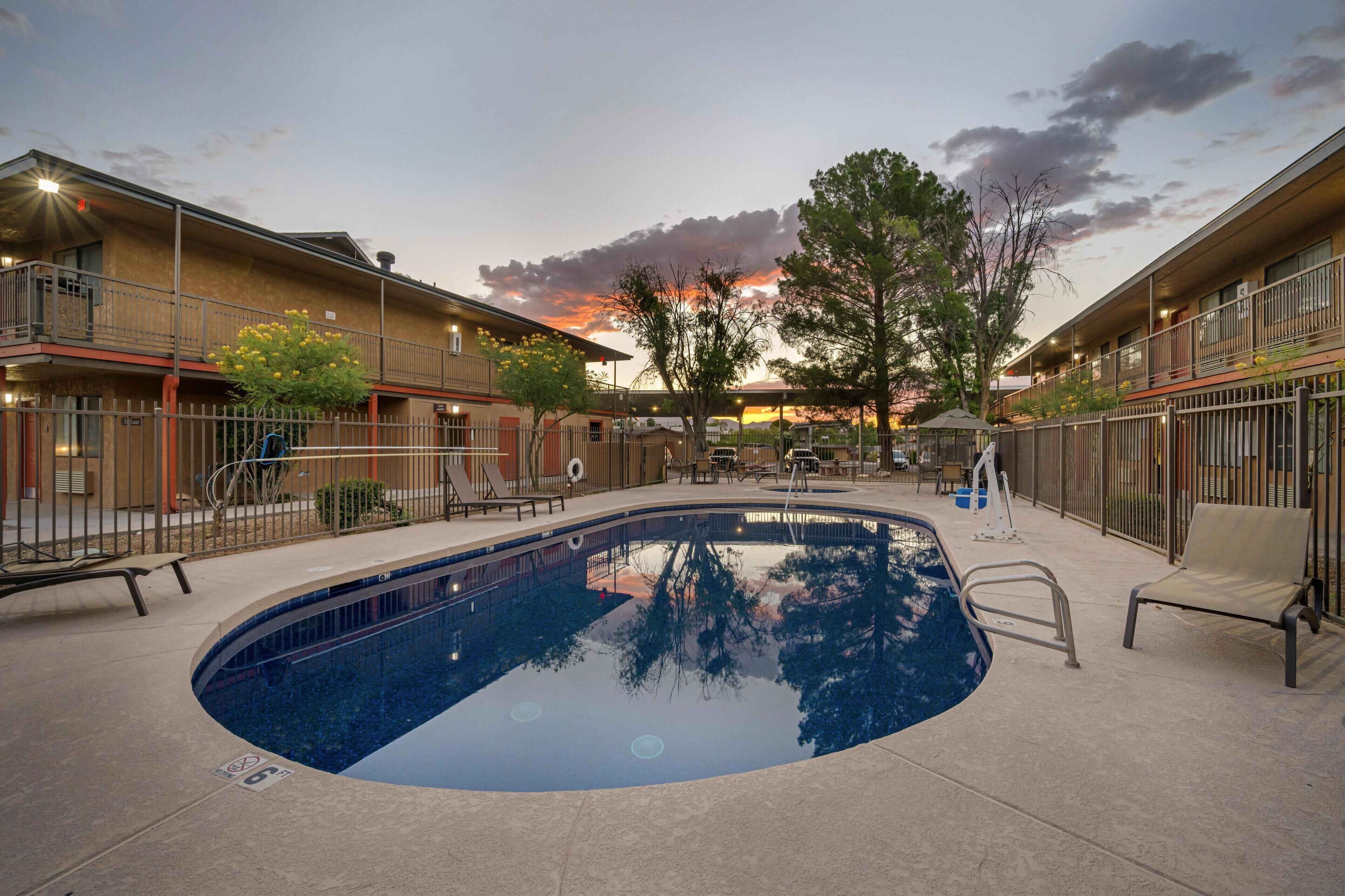 A pool area with a clear view of the sky and surrounding buildings.