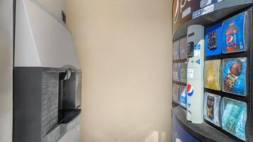 A vending machine with various beverage options, including Pepsi and Mountain Dew, and a refrigerator with a beverage dispenser.