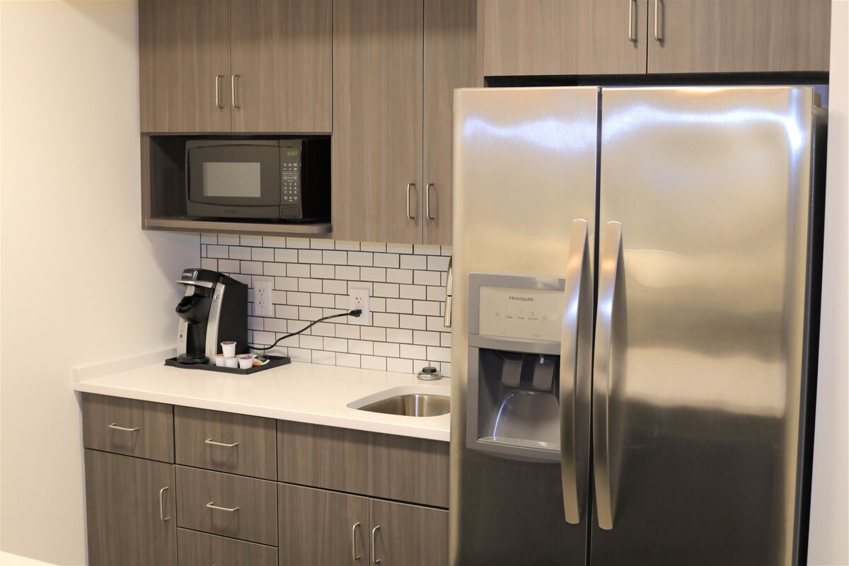 A modern kitchen with stainless steel appliances, a built-in microwave, and a coffee maker.