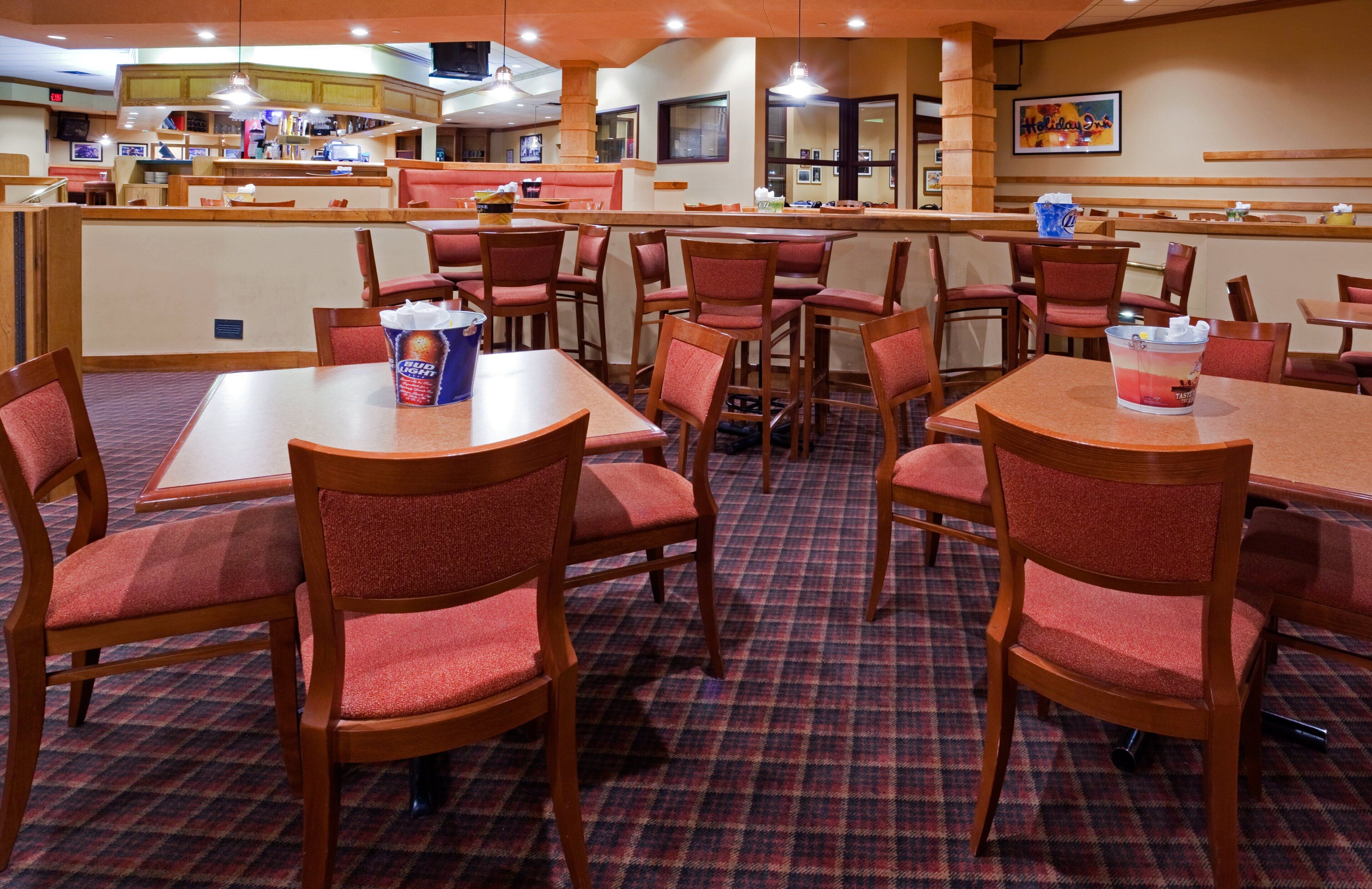 A restaurant with booths and tables, some with Bud Light cans.