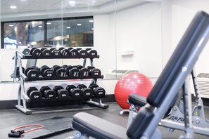 A gym with a bench, dumbbells, and a red exercise ball. - Holiday Inn & Suites St. Cloud by IHG (St Cloud)