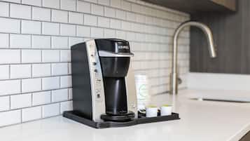 Una cafetera Keurig sobre una encimera blanca con un salpicadero de azulejos.