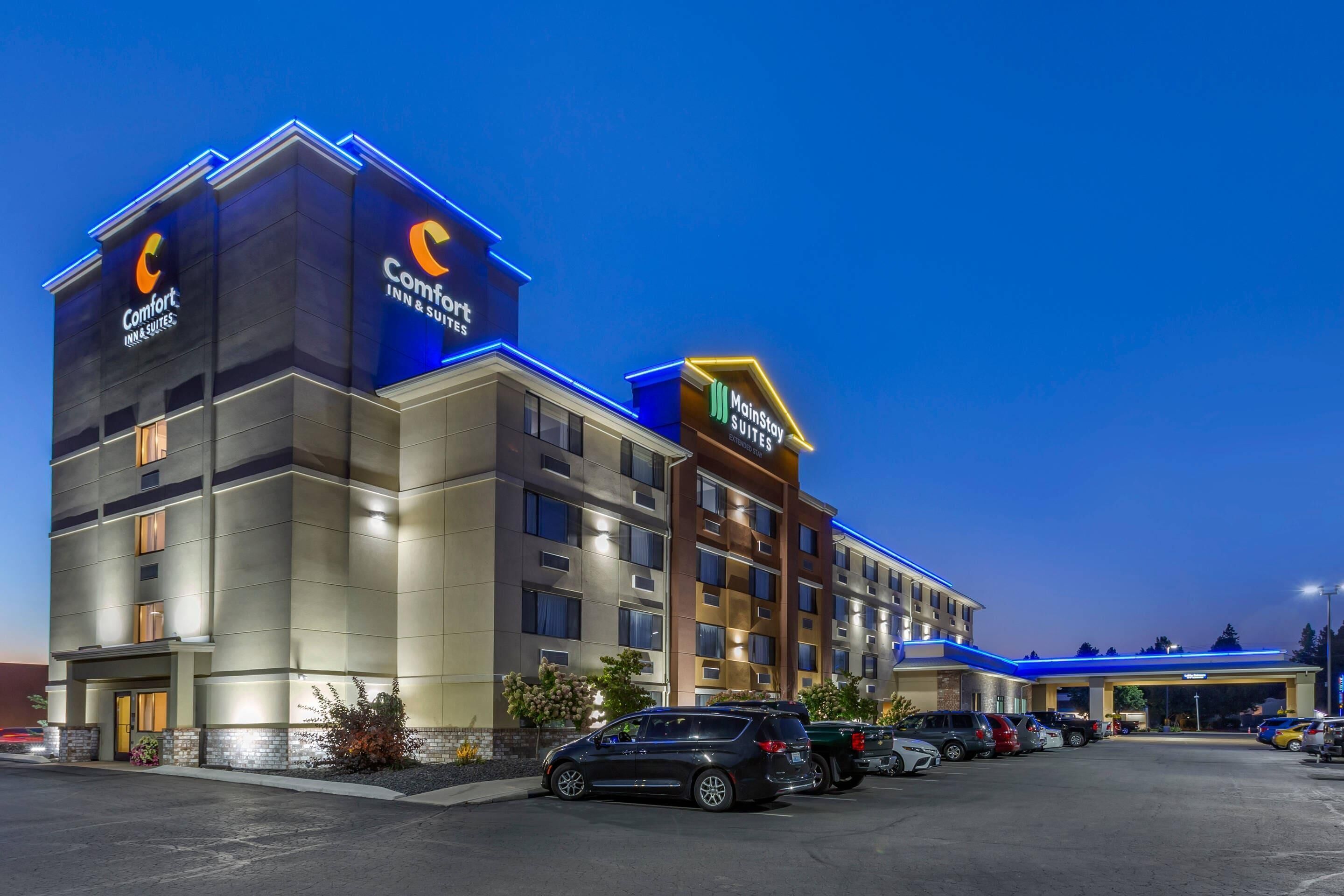 A hotel with multiple floors, a parking lot, and a MainStay Suites sign.