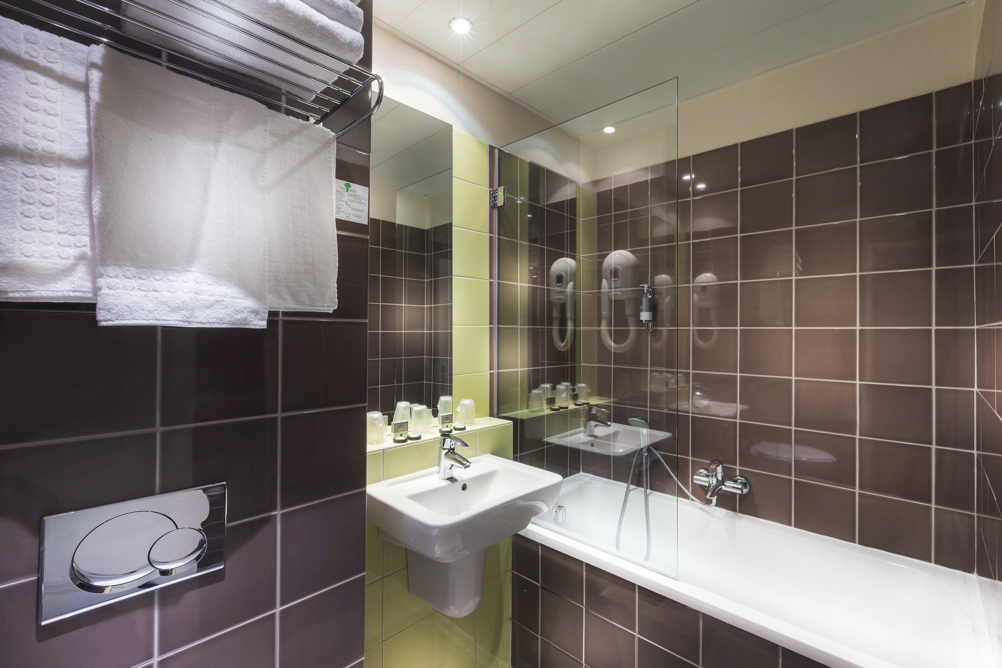 A modern bathroom with a large mirror, a sink, and a bathtub.