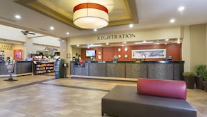 Ein Hotelbereich für die Anmeldung mit einer Rezeption, einer Lounge und einem Imbissstand.