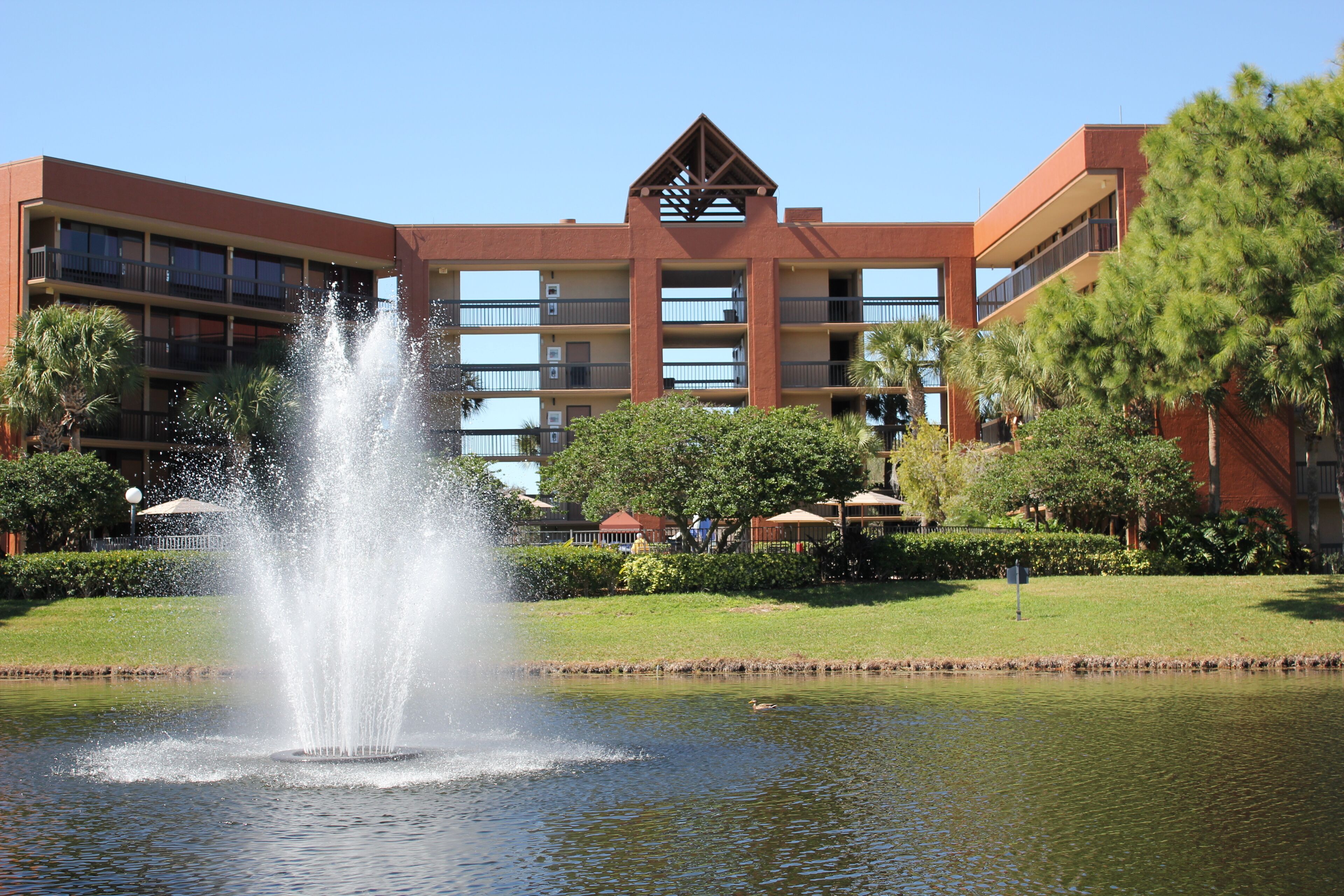 A hotel with a central courtyard, a fountain, and a swimming pool.