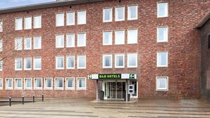 Een bed en breakfast hotel met een gevel van baksteen, meerdere ramen en een heldere lucht.
