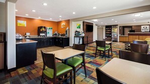 A hotel dining area with a counter, seating, and a coffee machine. - Quality Inn & Suites Bozeman (Bozeman)