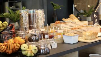 Um buffet de café da manhã com diversos alimentos e acompanhamentos.