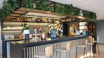 Een bar met een toonbank, barstoelen en flessenkasten vol flessen.