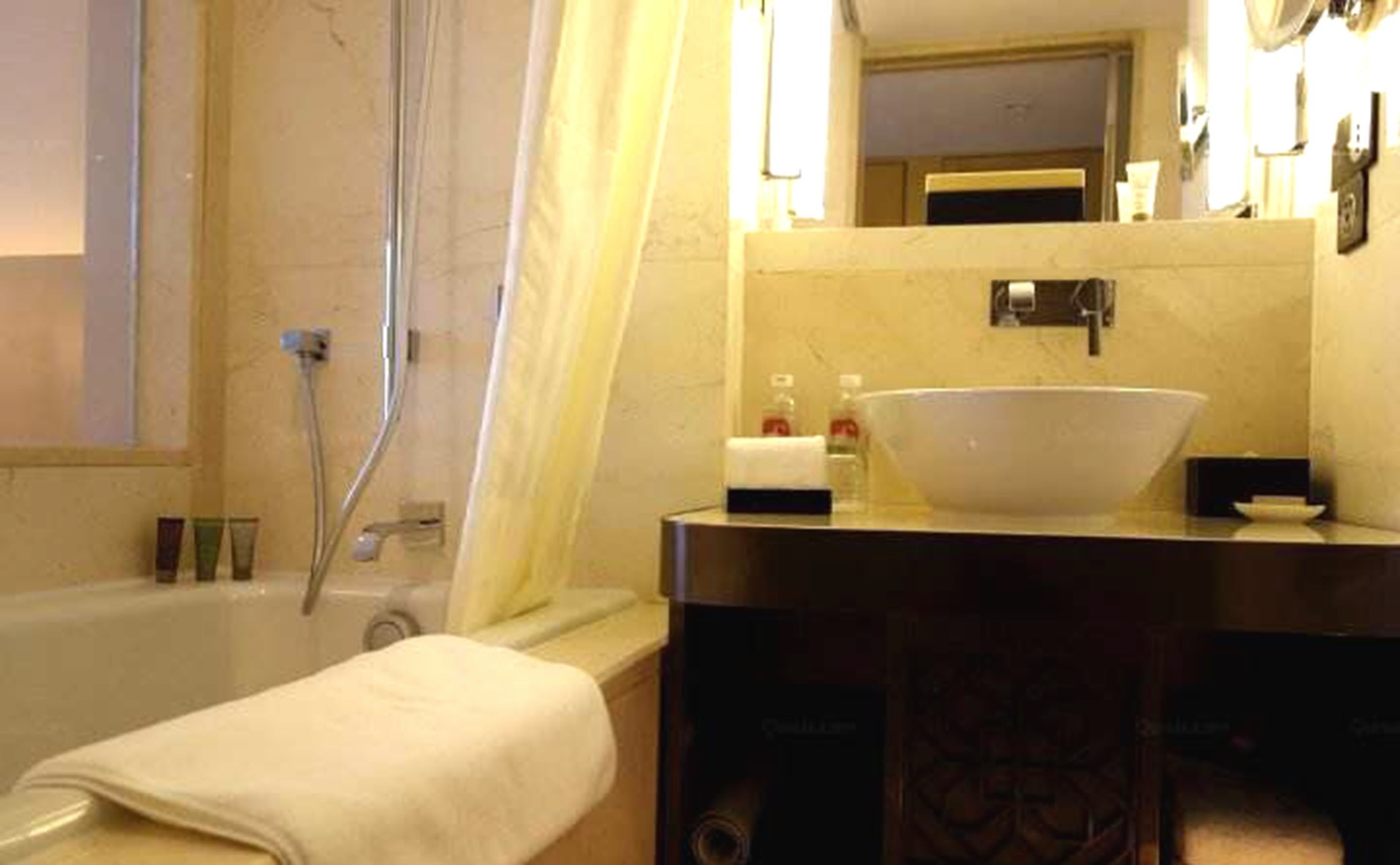 A bathroom with a bathtub, a sink, and a mirror.