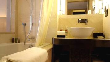 A bathroom with a bathtub, a sink, and a mirror.