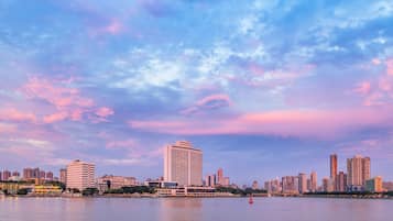 A city skyline with high-rise buildings and a body of water in the foreground.