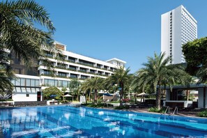 Una piscina al aire libre, sombrillas, tumbonas