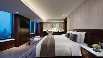 Ein modernes Hotelzimmer mit einem großen Bett, einem Schreibtisch, einem Stuhl und Blick auf die Stadt.