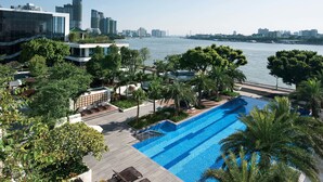 A rooftop pool with a city skyline view, surrounded by greenery and modern buildings. - White Swan Hotel (Guangzhou)