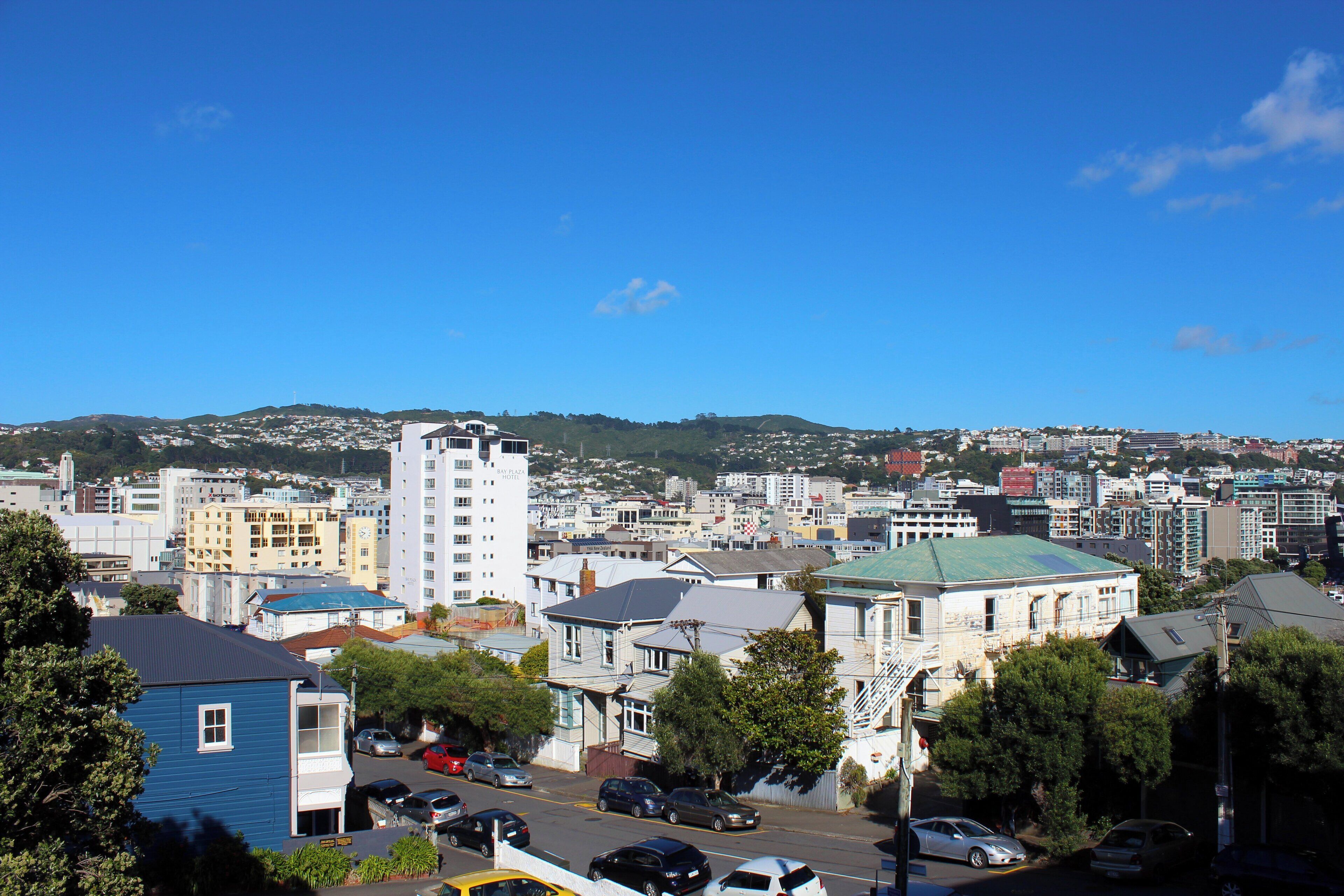 A residential area with various buildings, including a tall white apartment building and a blue house.