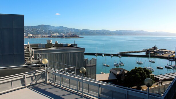 A marina with boats docked, a clear sky, and a distant cityscape. - Copthorne Hotel Wellington Oriental Bay (Wellington)