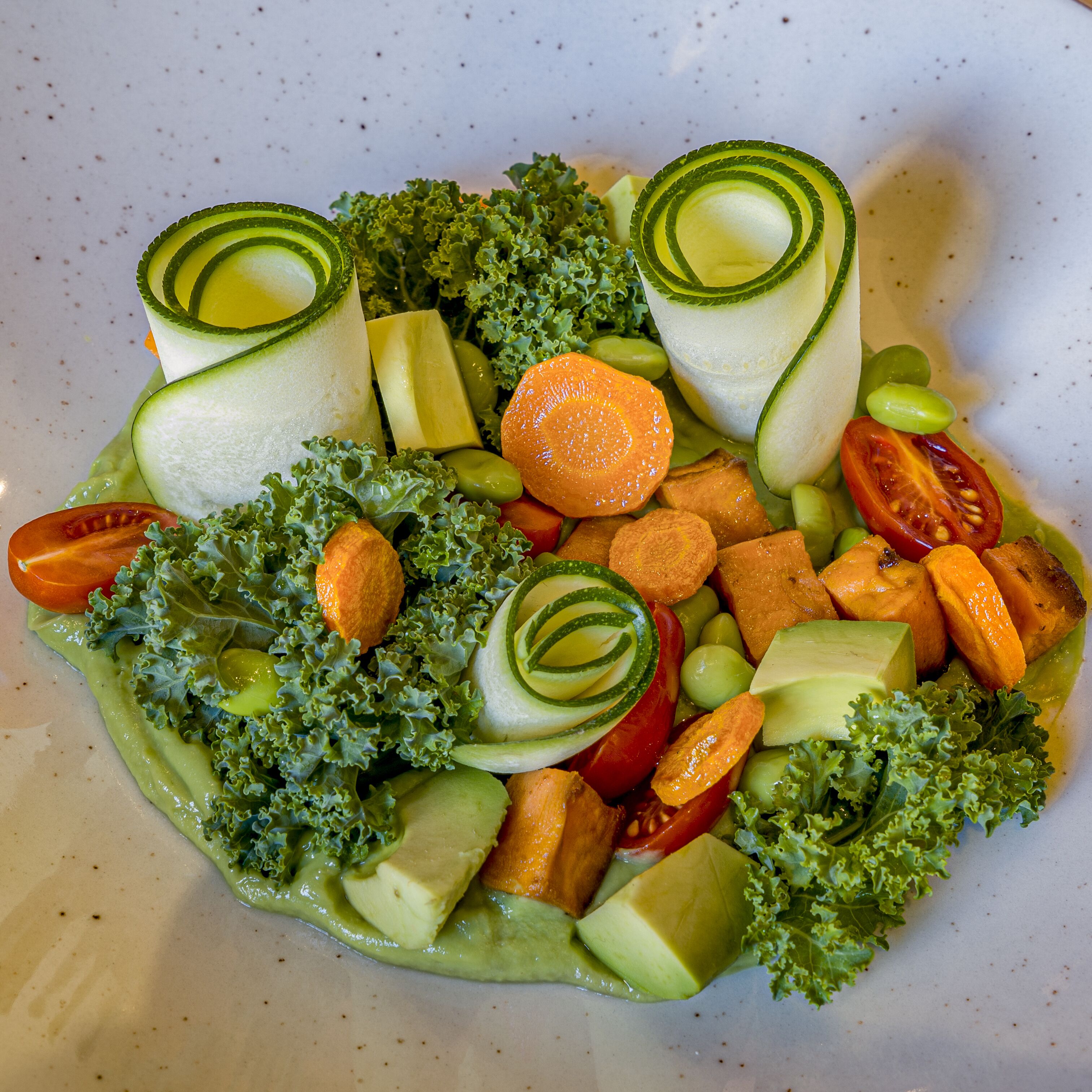 Ensalada con diferentes verduras y aderezo cremoso.