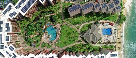 A resort with multiple buildings, a swimming pool, and a beach.