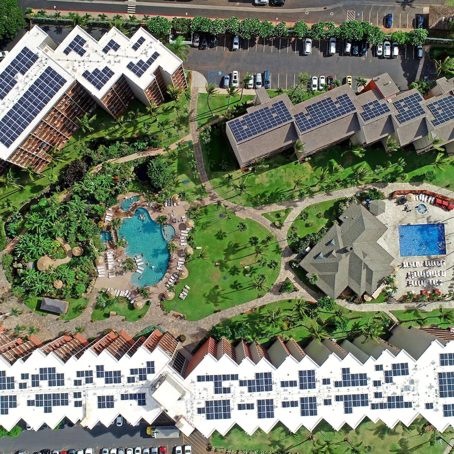 A resort with multiple buildings, a swimming pool, and a beach.