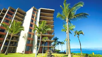 A hotel with multiple floors, balconies, and a view of the ocean.